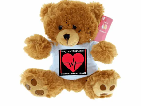 Teddy bear holding a heart-themed sign with a heartbeat graphic.