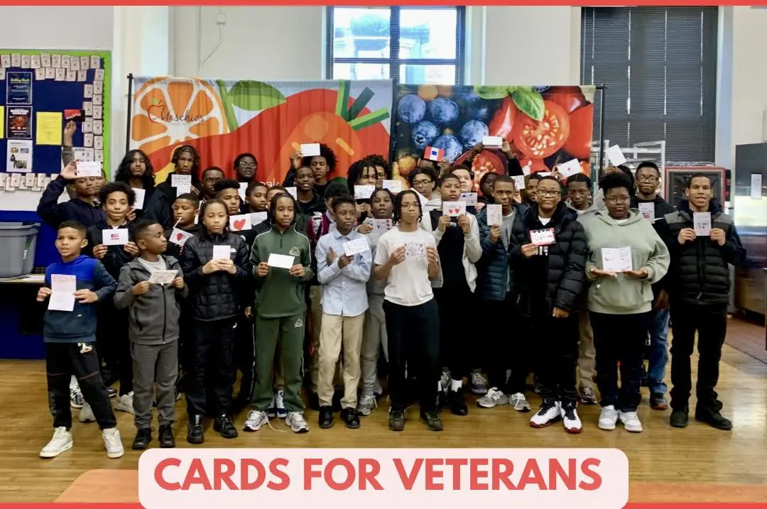 Group photo of volunteers holding cards for veterans.