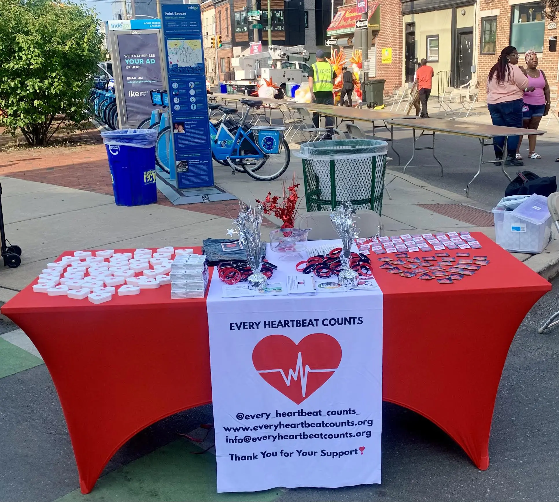 A red table with heart-themed items and a sign promoting blood donation awareness.