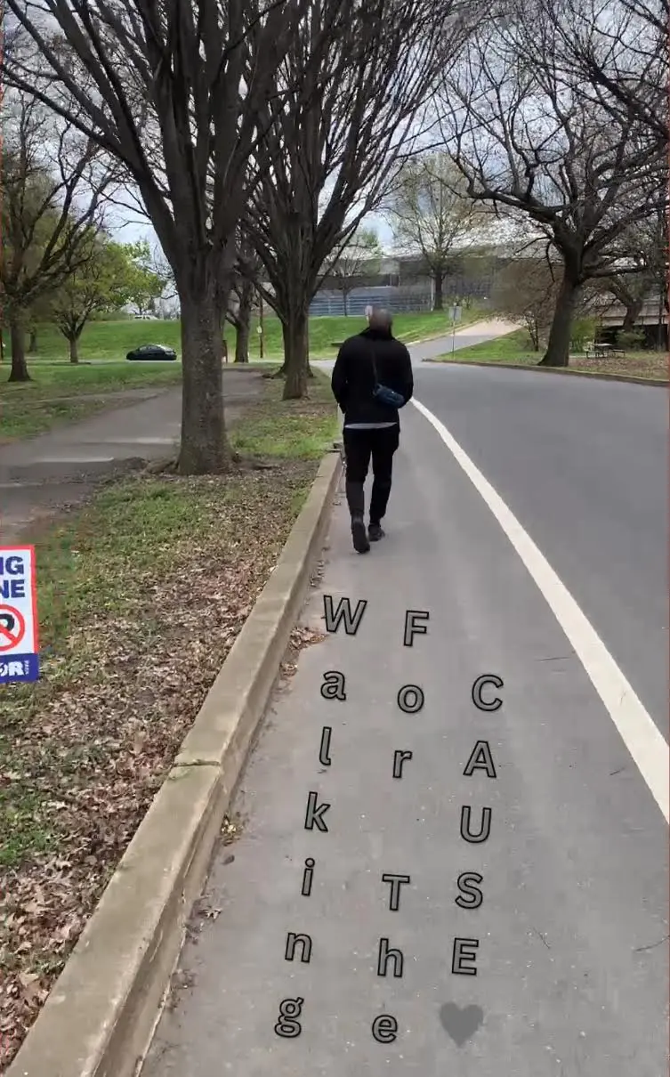 A person walking on a path with confusing sidewalk text.