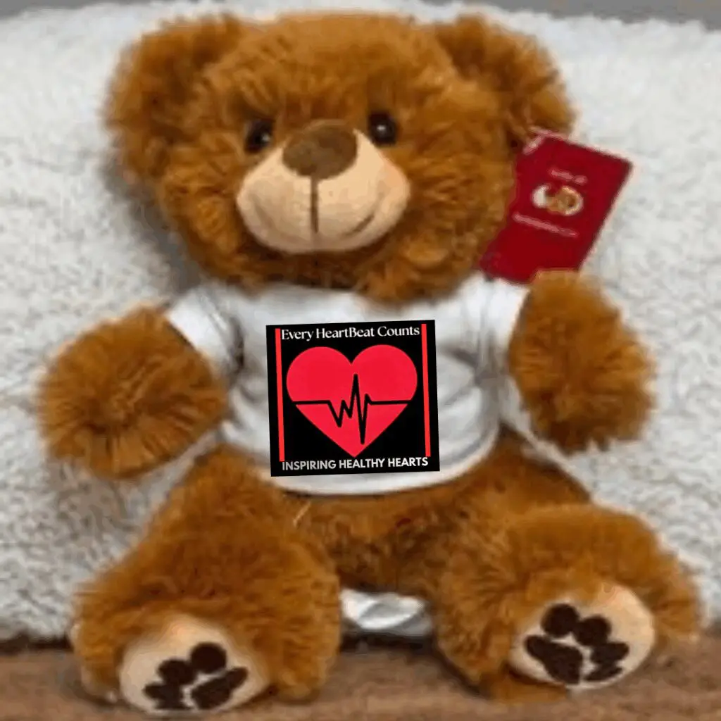 A teddy bear holding a heart-themed sign about love and life.