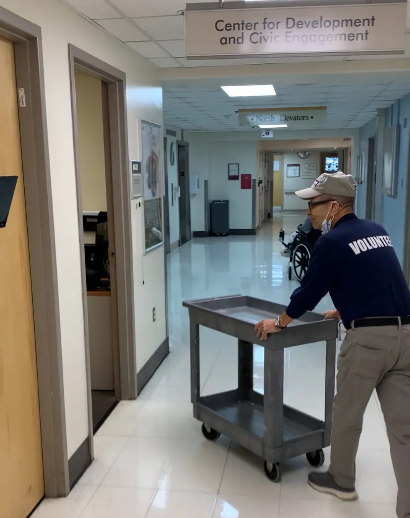A janitor cleaning a hallway with a mop and bucket.